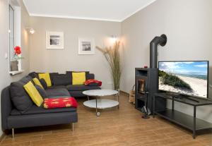 uma sala de estar com um sofá e uma televisão de ecrã plano em Haus LUV em Insel Poel