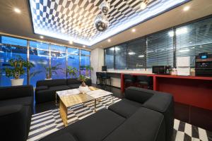 eine Bar mit Sofas und einem Tisch in einem Raum in der Unterkunft BON Hotel BUSINESS in Busan