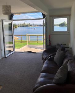 a living room with a couch and a view of the water at Lake View Lodge in Chichester