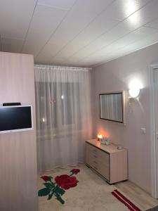 - un salon avec une télévision et une commode dans l'établissement Riverside Apartment Pärnu, à Pärnu