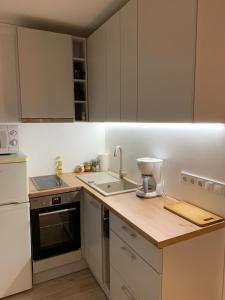 une cuisine avec des armoires blanches et un mixeur sur un comptoir dans l'établissement Riverside Apartment Pärnu, à Pärnu