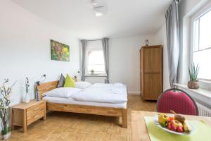 a bedroom with a bed and a table with a bowl of fruit at Der Teichhof in Grandenborn