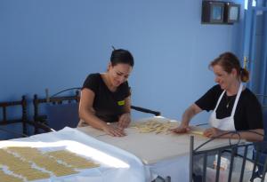 two women sitting at a table making cookies at Hotel Palladio in Giardini Naxos