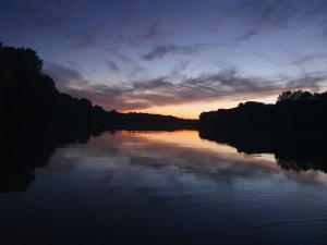 a view of a river at sunset at Bence Apartman in Tiszabábolna