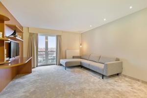 a living room with a couch and a television at Verac Flats in Zaventem