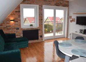 a living room with a table and chairs and a brick wall at Apartament Nad Dzika Plaza in Puck