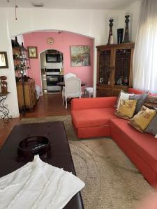 een woonkamer met een rode bank en roze muren bij Ne Miami Cottage in Miami