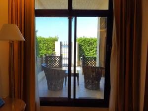 vistas a un balcón con mesa y sillas a través de una ventana en Roda Beach Resort en Dubái