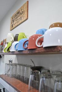 a shelf with bowls and glasses on it at Ruca Kiñe Hostel in Las Grutas