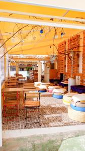 a restaurant with tables and chairs and a yellow ceiling at Aguere Nest Hostel in Las Lagunas