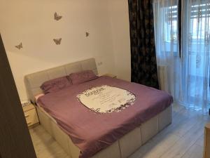 a bedroom with a bed with a purple blanket at Apartament modern Târgoviște în regim hotelier in Târgovişte