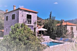 een stenen huis met een zwembad ervoor bij ORATO VILLAGE in Pyrgos
