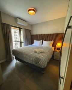 a bedroom with a bed with two towels on it at Flat Jardins - Paulista in Sao Paulo