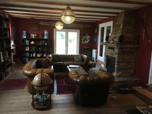 a living room with leather furniture and a fireplace at Hørhaven B&B in Fuglebjerg