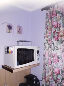 a microwave sitting on a shelf in a kitchen at Kwatera na Bagnach in Osowiec