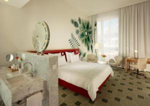 a bedroom with a bed and a sink and a mirror at HYPERION Hotel Dresden Am Schloss in Dresden +26 photos