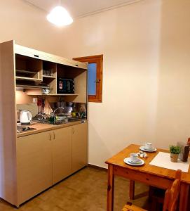 małą kuchnię ze stołem i stołem oraz jadalnię w obiekcie Nicoll Apartments w Acharavi