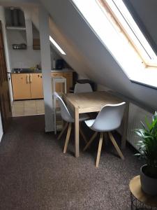 ein Esszimmer mit einem Tisch und Stühlen im Dachgeschoss in der Unterkunft Ferienwohnung Willi II in Spremberg