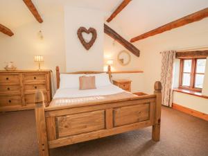 A bed or beds in a room at Stable End Cottage