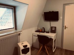 a small room with a desk and a television at Hotel Centraal in Harlingen