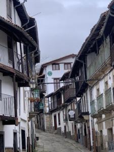un callejón con edificios blancos con balcones. en Aptos La Ceja, El Trampal y El Reloj by CASA BOLDO, en Candelario