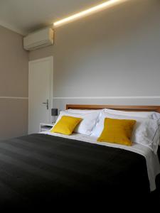 um quarto com uma cama com duas almofadas amarelas em ARIA DI MARE, Manarola - Appartamento THE VIEW em Manarola