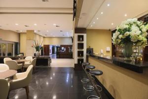 a lobby with a bar with a vase of flowers at Nobile Suítes Uberlândia in Uberlândia