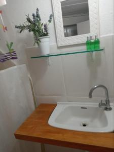 a bathroom with a sink and a mirror on a counter at Porão reformado no centro de Floripa in Florianópolis