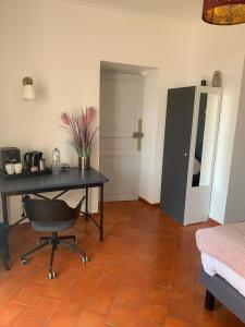 Zimmer mit einem Schreibtisch, einem Tisch und einem Stuhl in der Unterkunft CHAMBRE D'HOTE in Gignac