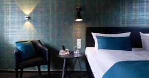a bedroom with a bed and a chair and a table at Trend Hotel in Oldenburg