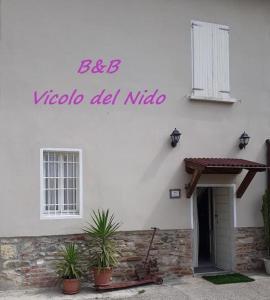 een wit gebouw met potplanten ervoor bij Vicolo Del Nido B&B in Paderno Franciacorta