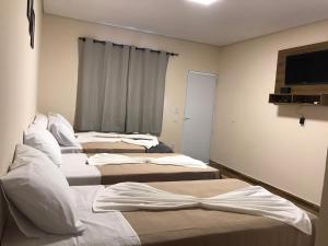 three beds in a room with a window at Pousada Morada dos Pássaros in Capitólio +64 photos