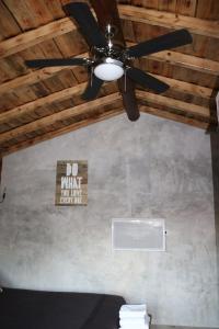 a ceiling fan in a room with a sign on the wall at Palheiro do Malgas in Lousã