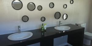 a bathroom with two sinks and mirrors on the wall at EEZY BREEZY HOLIDAY HOME in Knysna