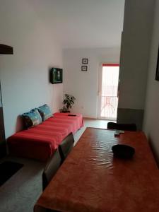 Cette chambre comprend un lit et une table avec une couverture rouge. dans l'établissement Gordana Apartments, à Fažana