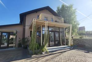 阿尔杰什河畔库尔泰亚Pensiunea Prestige House的前面有植物的房子