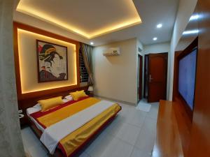 ein Schlafzimmer mit einem Bett und einem Wandgemälde in der Unterkunft Cát tường 2 hotel in Ho-Chi-Minh-Stadt