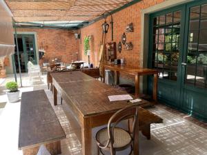 um pátio com uma mesa de madeira, bancos e uma parede de tijolos em Villa Serena Bed & Breakfast em Embu