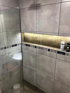 Roseus Hotel Boutique في Miramar: حمام مع جدران حديد غير قابل للصدأ ومغسلة