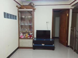 sala de estar con TV y centro de entretenimiento en Widodaren Homestay en Probolinggo