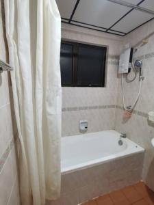 a bathroom with a bath tub and a window at D'Sofiya Homestay A Famosa Melaka in Melaka