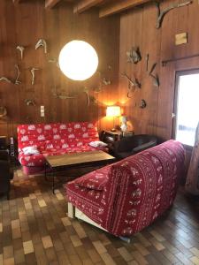 a living room with a red couch and a table at Boost Your Immo Chalet Vars 371 in Vars