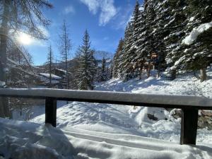 a fence covered in snow next to some trees at Boost Your Immo Chalet Vars 371 in Vars