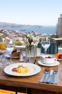 - une table avec une assiette de nourriture et des verres à vin dans l'établissement Hotel Boutique Casa Recreo, à Viña del Mar