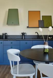 une cuisine avec des armoires bleues, une table et des chaises dans l'établissement T9 Zakopane, à Zakopane