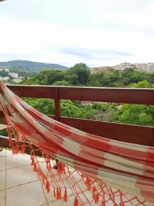 un balcón con hamaca y vistas en Casa com linda Vista no Centro, en Serra Negra