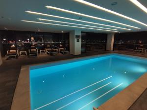 une piscine dans le hall de l'hôtel avec un bar dans l'établissement Ramada Encore by Wyndham Monterrey Apodaca Zona Aeropuerto, à Monterrey