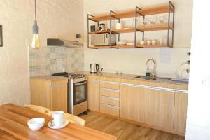 a kitchen with wooden cabinets and a wooden table at Fincas del Real in Colonia del Sacramento