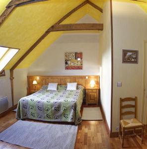 Chambre d'hotes Au Vieux Moulin في كلووار كارنووي: غرفة نوم بسرير في العلية