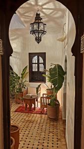 馬拉喀什的住宿－Dar Salam - All Inclusive - 2023 Best Hospitality Award，一间设有吊灯、桌子和植物的房间